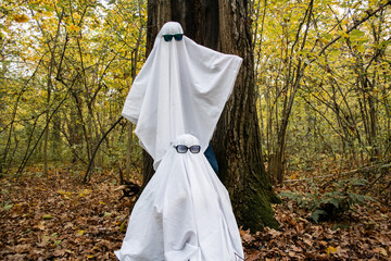 Ghost challenge in the forest or park. Two unrecognizable people teenagers disguised as ghosts with...