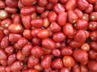 High angle close-up view of fresh red Roma tomatoes displayed for sale at a grocery market