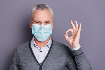 Portrait of top manager wearing mask casual formal-wear showing ok-sign isolated over gray pastel background