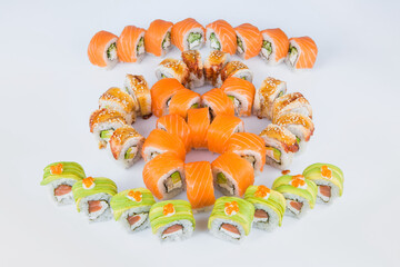 Large Set of sushi roll pieces with Philadelphia cream cheese. Big Variety of eastern food snack slices with raw salmon, unagi eel, avocado and red caviar served and isolated on background.
