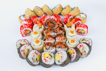 Large Set of sushi roll pieces with seafood and raw fish. Futomaki and tempura sushi rolls. Big Variety of eastern food slices with different seafood ingredients isolated on background. 
