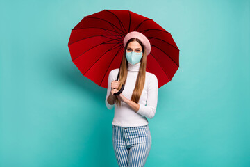 Photo of pretty traveler lady hold umbrella wear medical mask specs beret turtleneck jeans isolated...