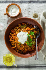 rice with vegetables and yogurt. in earthenware on a linen tablecloth
