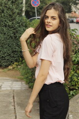 Young girl with long brown hair poses outside