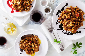 fusilli bolognese pasta with red wine on a marble table. Italian Cuisine