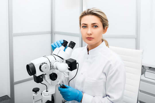 Experienced caucasian gynecologist woman sitting near a colposcope in her gynecological office. Gynecologist profession. Women's health