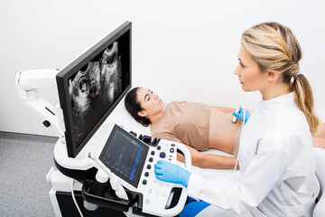 Woman having an ultrasound examination of uterus and ovaries at the gynecologist office in a modern...