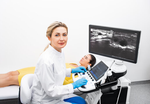 Portrait of woman ultrasound doctor during ultrasonography procedure for a young female patient at a modern clinic