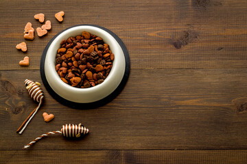Dry cat food in bowl with toy, top view