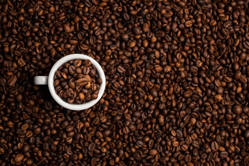 cup full of coffee beans over a background of coffee beans