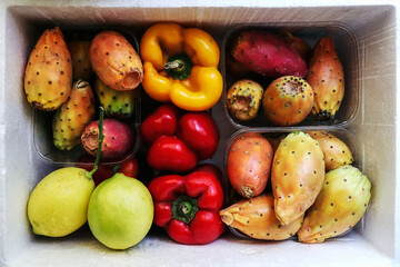 Colorful fresh fruits and vegetables: prickly pears, opuntia cactus figs, yellow and red pepper bells and lemons