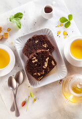 chocolate loaf cake with walnuts and prunes on the table with green tea. pause coffee