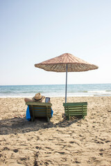 a man sitting at the beach with his e-reader