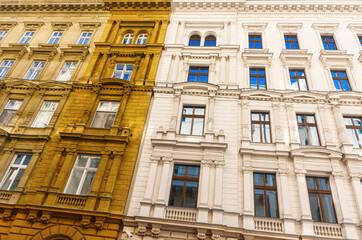 Monumental white and yellow ochre colored facade in neoclassical architectural style with ornamented windows. Budapest, Hungary.