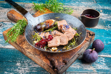 Traditional cooked sliced veal tongue figs and cranberries offered as close-up in a rustic...