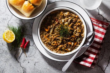 lentil soup with vegetables and bread rolls on a concrete background. healthy vegan meal