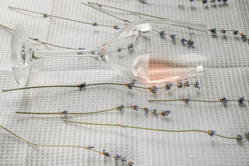 Lavender and a sip of rose wine in a glass. The glass lies on a white waffle cotton towel.