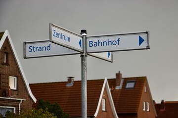 Straßenschild mit der Auschrift "Zentrum, Bahnhof, Strand", Wegweiser