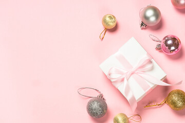 Fototapeta na wymiar Christmas pink flat lay background with present box and decorations.