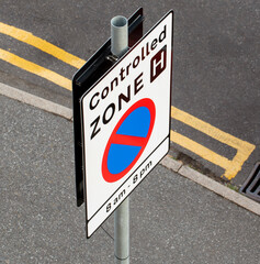  UK. 2020. Roadsign for a controlled zone, no parking between 8am and 8pm. No waiting and double yellow lines.