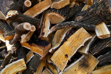 Firewood of different shapes piled up in bunch close up