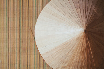 Round straw hat hanging on empty wall