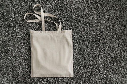 White blank cotton bag on grey fluffy background. Mockup and zero waste concept.