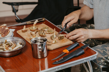 Hands cut raw mushrooms with sharp knife