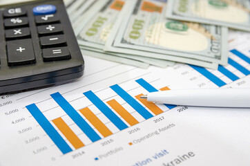 Obraz premium Business graphs and charts report with pen, calculator on desk of financial advisor. Financial abstract concepts.