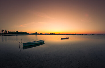 Łódki na tle zachodzącego słońca