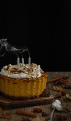 Homemade  pumpkin cheesecake on a dark and wood background.