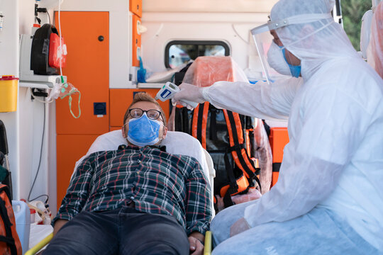 Paramedic Is Taking The Temperature Of A Young Man In Ambulance