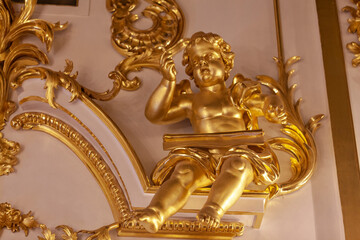 A child with a book. Gilded wood carvings