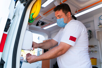 Ambulance staff disinfections his hands