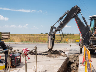 Drilling machine working in a trench with new water pipes in the ground of street.