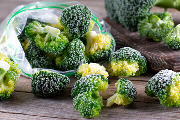 Fresh frozen broccoli in a plastic bag on wooden table