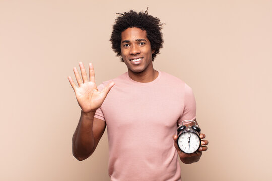 Young Black Afro Man Smiling And Looking Friendly, Showing Number Five Or Fifth With Hand Forward, Counting Down