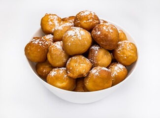 sweet donuts laid out pyramid sprinkled with powdered sugar on the plate