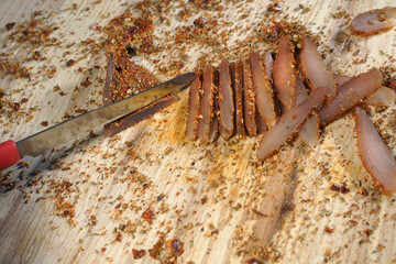  A man cuts dried pieces of grilled meat, chicken chips.