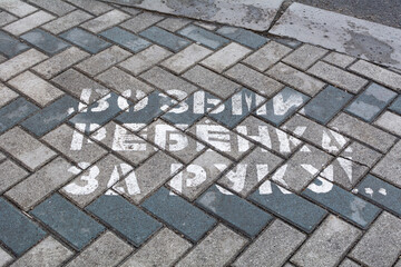 Pedestrian signs. On the asphalt there is an inscription - Take the child by the hand - to attract the attention of pedestrians in order to reduce road accidents.