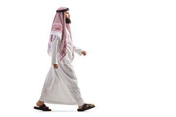 Full length profile shot of an arab man in a traditional thobe walking