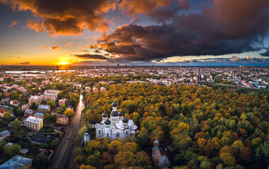 Aerial view of Riga city at colorful sunset. Impressive storm clouds over the city park in autumn colors. 