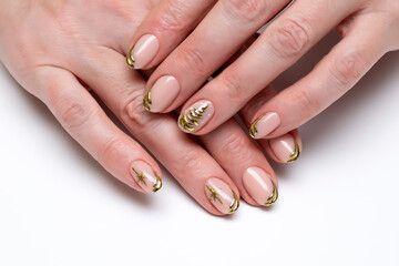 New Year's festive golden manicure with a painted tree and stars on short oval nails close-up on a white background. Gold casting.
