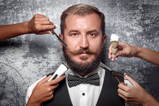 Professional barbershop. Portrait of a man with a beard and mustache. Service and care in 4 hands. Electric razor, blade, foam brush and scissor near the man's face