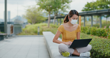 Woman wear face mask and work on laptop computer