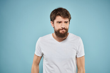 Obraz premium Man in white t-shirt emotions facial expression cropped view studio blue background lifestyle