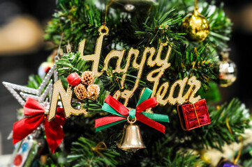 Happy new year lettered sign on the Christmas tree.