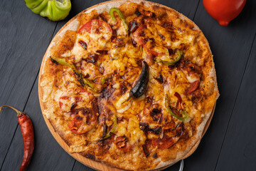 Vegetarian hot chili pizza on wholegrain flour dough on a wooden Board, top view