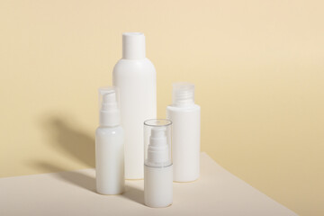 Set of white cosmetic bottles and jars with hard shadows. Home and beauty salon care concept