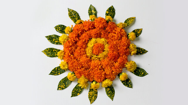 flower Rangoli for Diwali or pongal or onam made using marigold or zendu flowers and Leaves with Indian Traditional Pattern over on white background, selective focus.
